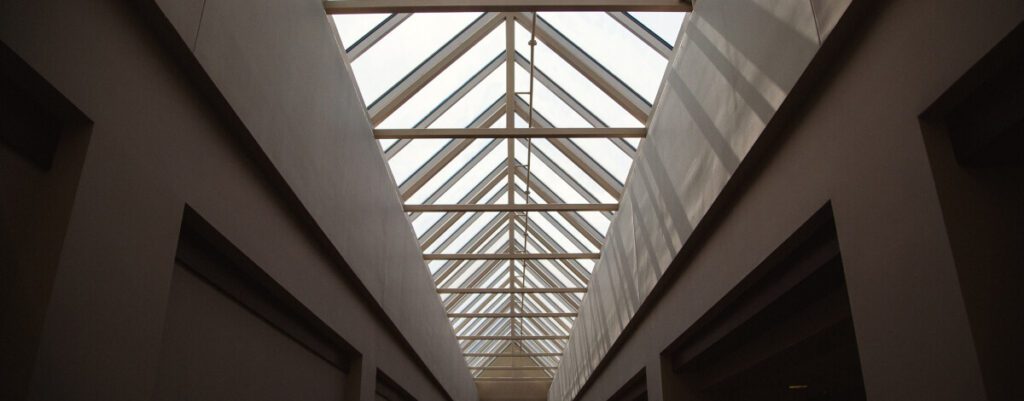 Long glass skylight roof over a commercial building corridor Long glass skylight roof over a commercial building corridor