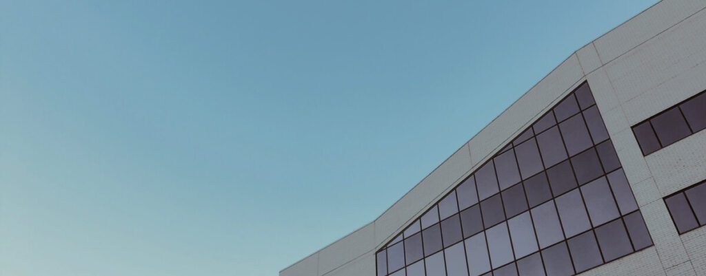 Commercial building roofline with metal panels against a blue sky