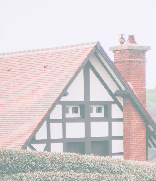 Tudor-style house with a red tile roof and brick chimney
