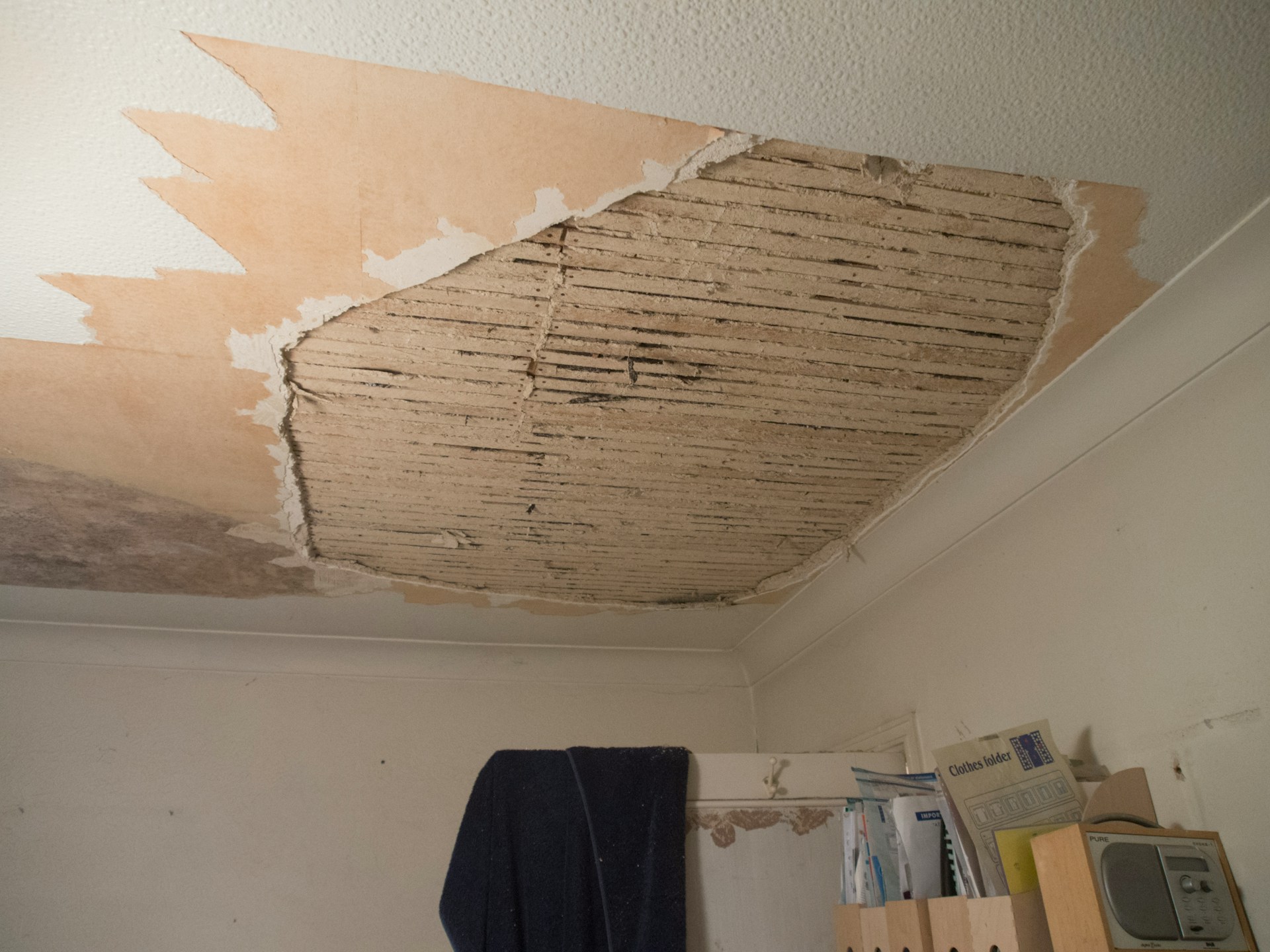 Ceiling with peeling paint and damaged drywall from a roof leak