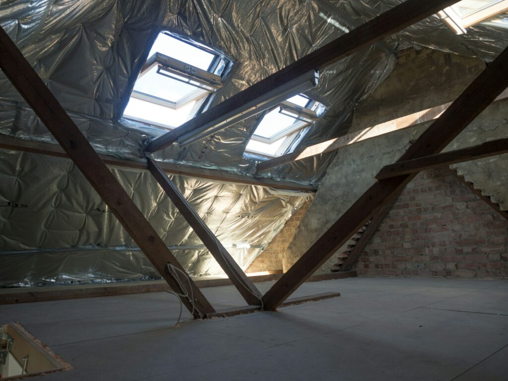 Attic with skylights and reflective insulation beneath the roof rafters Attic with skylights and reflective insulation beneath the roof rafters